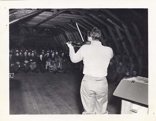 Menuhin playing for the assembled troops in a Shemya quonset hut.